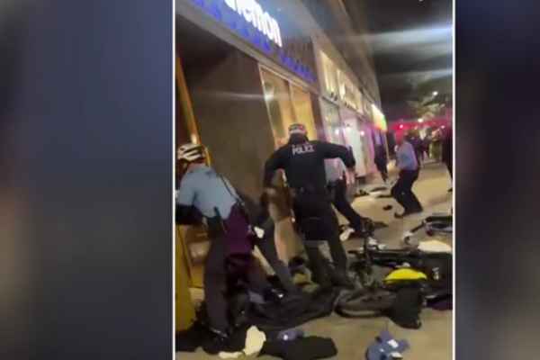 (Police charging on looters near stores): Police officers intervene as looters target stores.