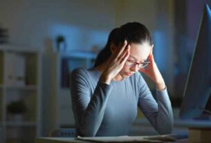 Female Expressing Anxiety at Her Desk - Article Focus: Anxiety.