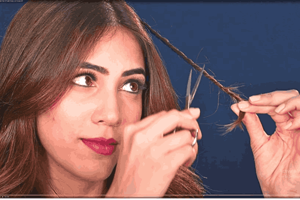 Woman trimming hair split ends - Taking action to remove split ends for healthier hair