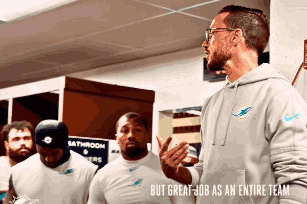 Miami Dolphins Coach addressing players in the locker room, guiding team success