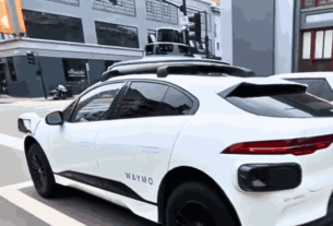 A Waymo autonomous taxi driving on a city street, symbolizing Waymo's expansion into Los Angeles and the Peninsula.