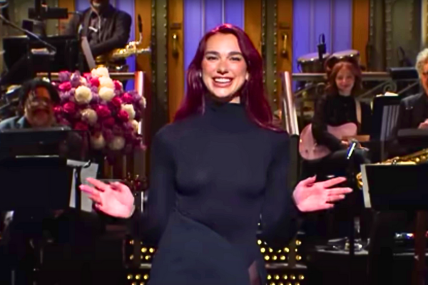 Dua Lipa shining on stage during SNL Tonight, hosting and performing in a vibrant atmosphere.