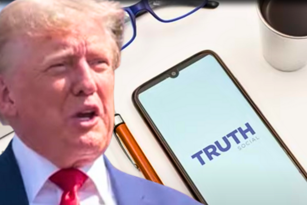 Former President Donald Trump stands confidently in front of a backdrop featuring the Truth Social logo, symbolizing his success with Trump Media's flagship platform, Trump TRUTH SOCIAL.