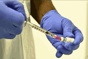A lab technician prepares a vaccine in a syringe to combat the Mpox outbreak.