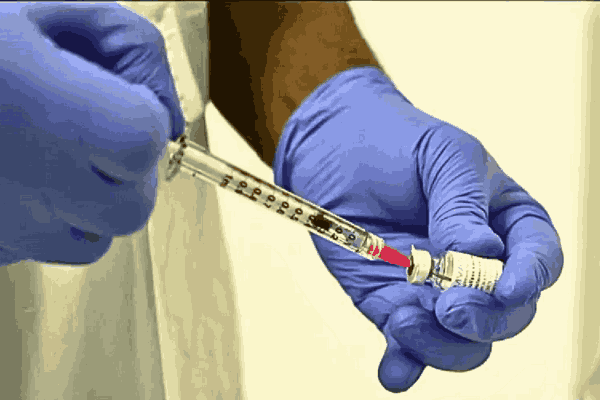 A lab technician prepares a vaccine in a syringe to combat the Mpox outbreak.