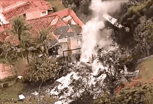 Aerial view of the aftermath of a devastating plane crash today near São Paulo, with wreckage scattered in a residential area.