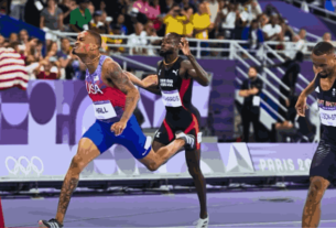 Quincy Hall crossing the finish line to win gold in the 400 meters at the Paris Olympics, capturing his incredible final surge.