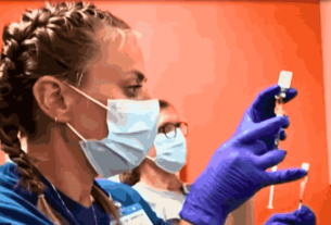 Healthcare professional wearing protective gear examining a patient amid the Mpox Outbreak in California.