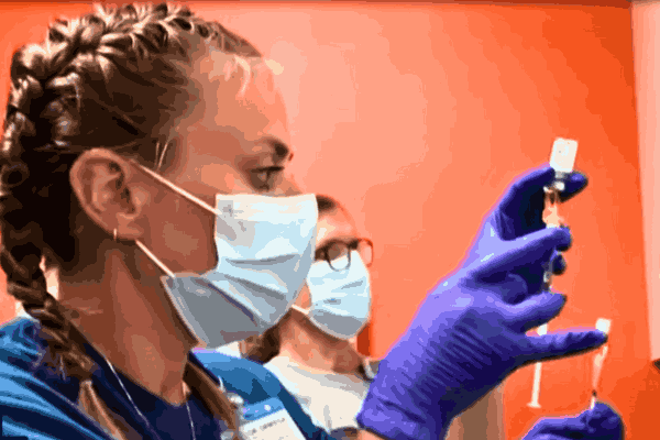Healthcare professional wearing protective gear examining a patient amid the Mpox Outbreak in California.