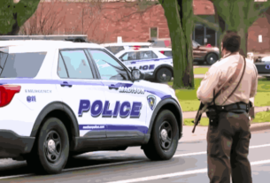 Police vehicles outside Abundant Life Christian School after the Wisconsin school shooting, with officers responding to the tragic incident.
