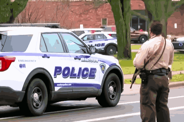Police vehicles outside Abundant Life Christian School after the Wisconsin school shooting, with officers responding to the tragic incident.